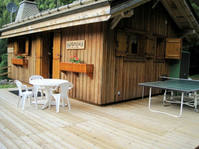 terrasse en bois devant le chalet  avec table de ping-pong